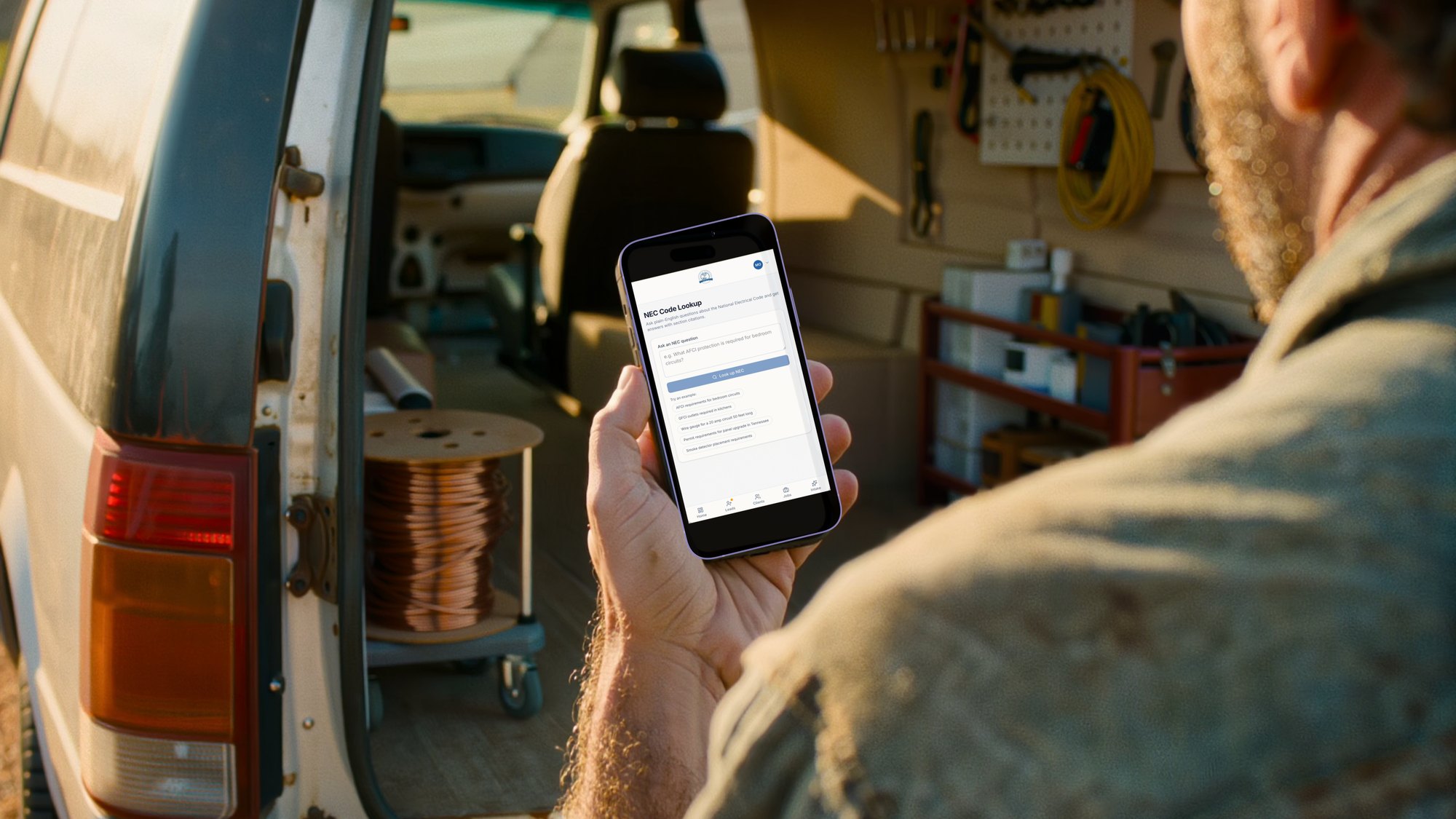 An electrician checking leads on the app from the back of his service van